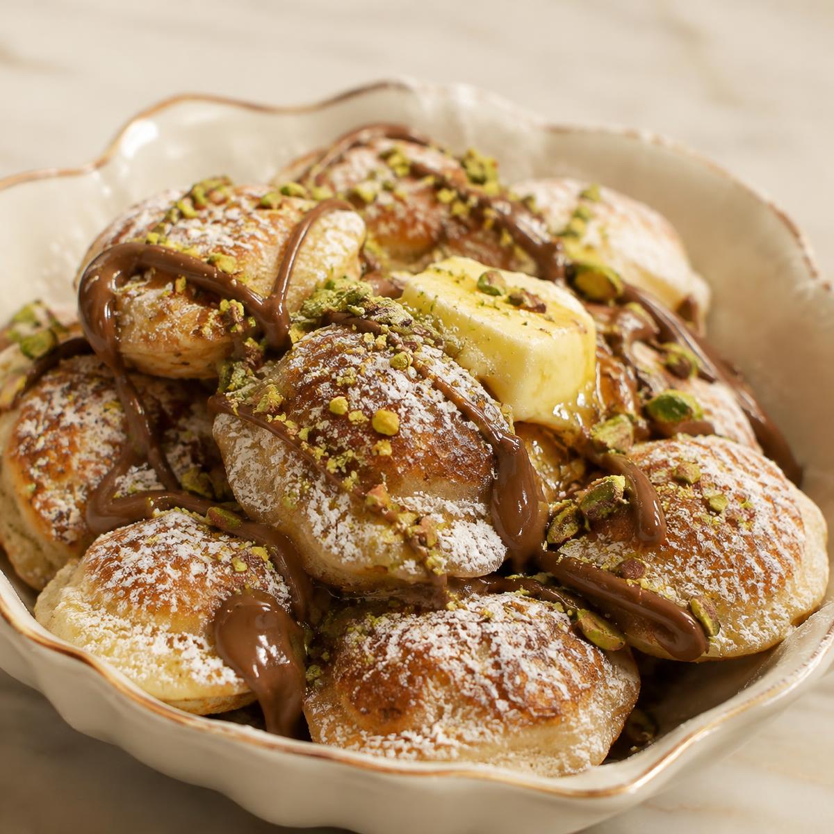 Poffertjes with powdered sugar, butter and pistachio